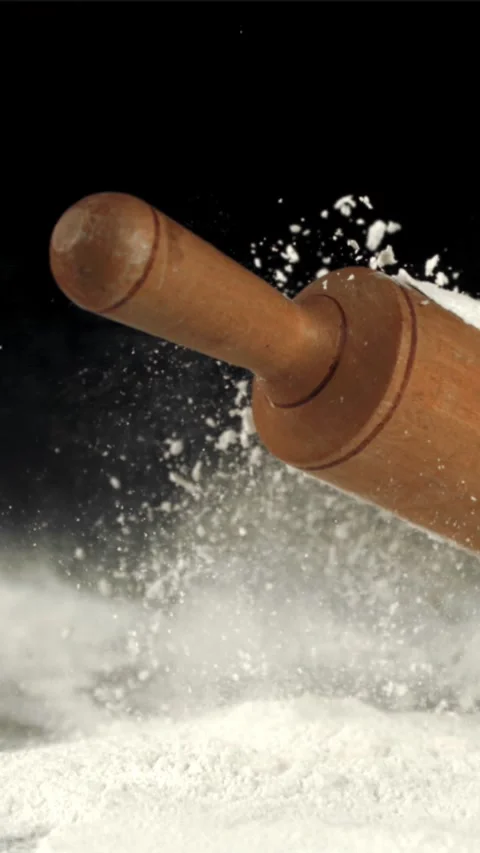 Super slow motion wooden rolling pin falls on the table with flour. Filmed on a Stock Footage 335287457