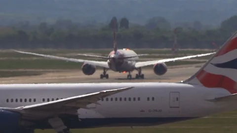 Super-telephoto plane accelerates down hot runway through heat shimmer v2 Stock Footage 111522804