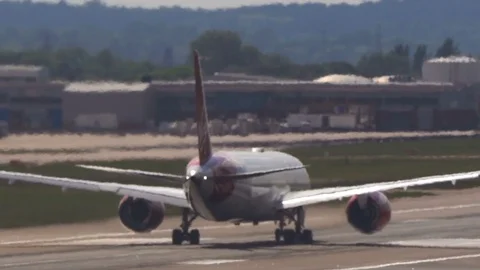 Super-telephoto plane accelerates down hot runway through heat shimmer  Stock Footage 111522831