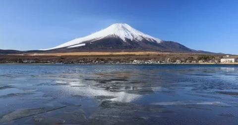 Superb view of Mount Fuji reflecting on frozen Lake Yamanaka on a clear winter Stock Footage 337451441