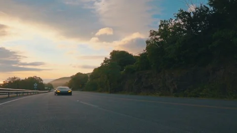 Supercar in a mountain road, sunset Stock Footage 99690831