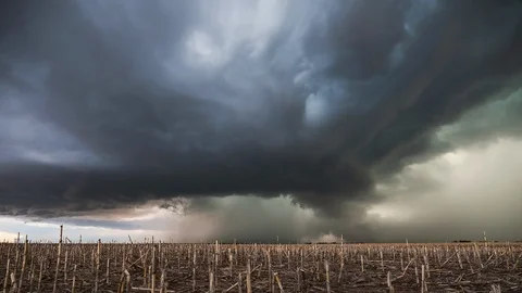 Supercell storm moving over corn field as clouds spin Stock Footage