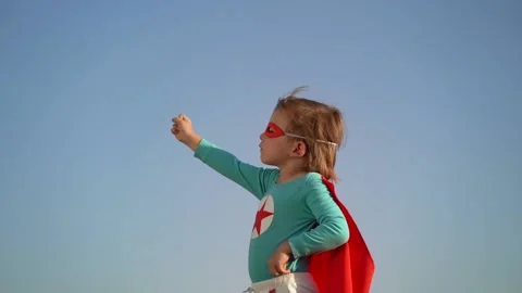 Superhero child against blue sky background. Slow motion Stock Footage