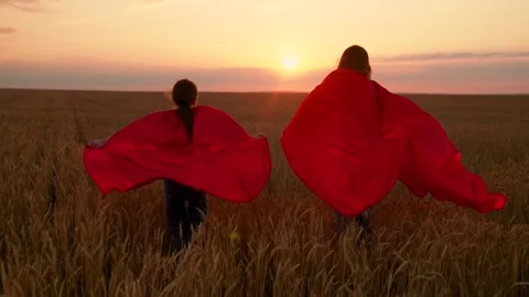 Superhero children running through wheat field. Girls playing in countryside Stock Footage 324759787
