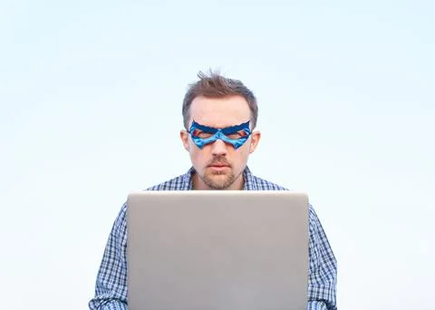 Superhero computer guy in blue mask using laptop outdoor Fotos Stock