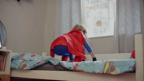 Superhero kid jumping on his bed Stock Footage 279220023