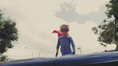 Superhero kid jumping on a trampoline Stock Footage 279186948