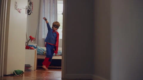 Superhero kid looking at himself in the mirror in his room Stock Footage 279220834
