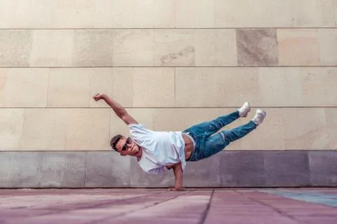 Superman flight, man acrobat dancer, handstand, dancing breakdance, summer city Stock Photos