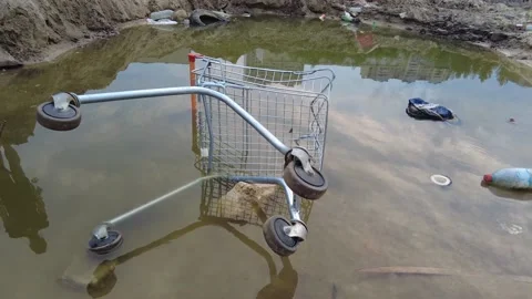 A supermarket cart is lying in a puddle after the rain, Stock Footage 158278577