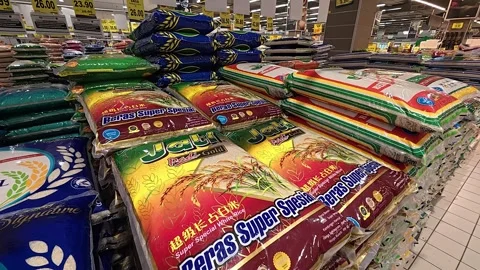 A supermarket display features plastic sacks of rice stacked high. Various Stock Footage 315483112