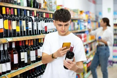 In supermarket man scan qr code from wine label Stock-Fotos