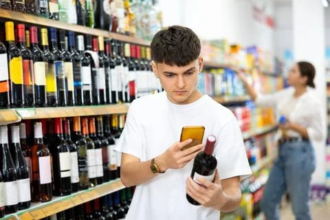 In supermarket man scan qr code from wine label Stock Photos