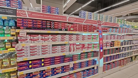 Supermarket Shelf Stocked with Various Toothpaste Brands &amp; Prices Stock Footage 318509281