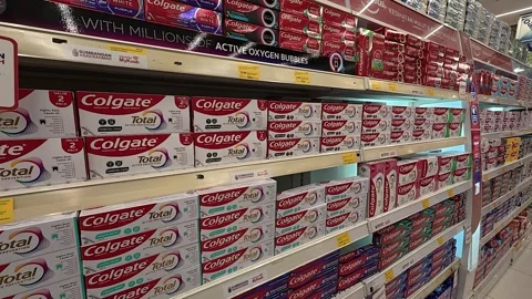 Supermarket Shelf Stocked with Various Toothpaste Brands &amp; Prices Stock Footage 318509307