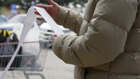 Supermarket shopping. Food Prices and Inflation. A young man checks the cost of Stock Footage 262532820