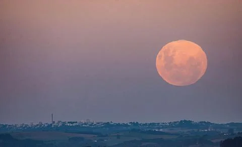 Supermoon over a distant cityscape Stock Photos