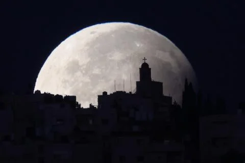Supermoon with a partial lunar eclipse sets over the old city of Jerusalem - 18  Stock Photos