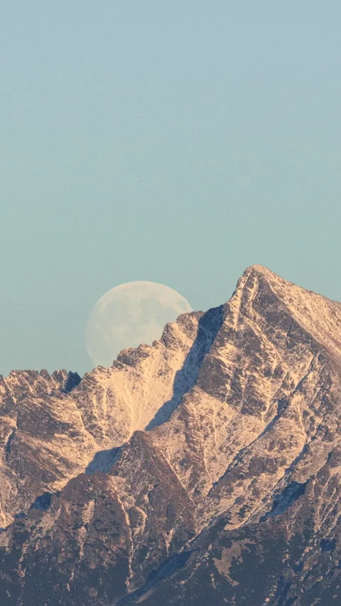 Supermoon rising from behind a mountain ridge. Stock Footage 320722923