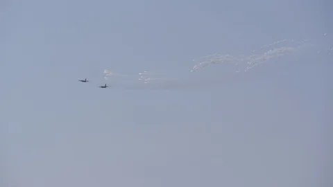 Supersonic planes in the blue sky perform aerobatics. The plane releases Stock Footage 120701355