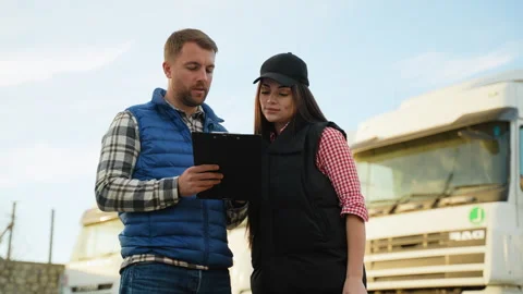 Supervisor and driver planning logistics at truck parking Stock Footage 299755164