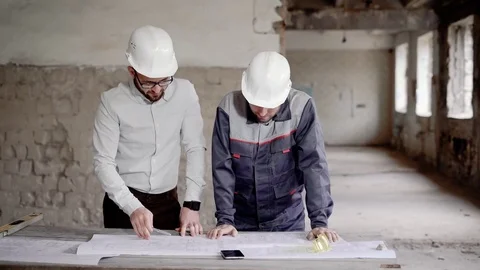 Supervisor and worker on construction. Foreman discussing project plan with Stock Footage 77133599