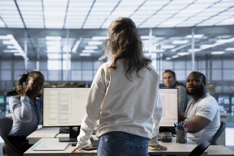 Supervisor checking on workers in data center, talking with them Foto stock