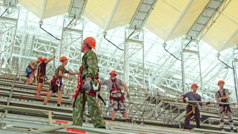 Supervisor controls workers at stadium construction site Stock Footage 236928899