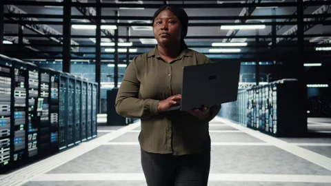 Supervisor in data center using laptop to deploy new server architecture Stock Footage 317126463