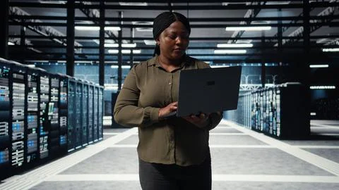 Supervisor in data center using laptop to deploy new server architecture Stock Photos