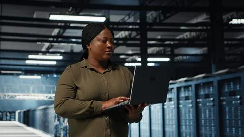 Supervisor in data center using laptop to deploy new server architecture Stock Photos