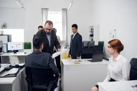 The supervisor inspects the work of Junior managers in the office of an Internet Stock Photos