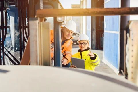 Supervisor instructing forklift driver what to work on next Stock Photos