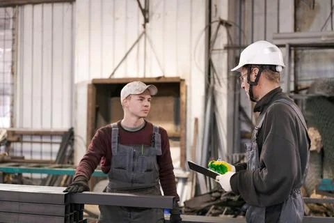 Supervisor Instructing Young Worker at Steel Storage Stock Photos