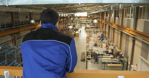 A supervisor or worker overlooks production of a large factory Stock Footage 91646818