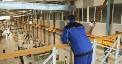 A supervisor or worker overlooks production of a large factory Stock Footage 91647210