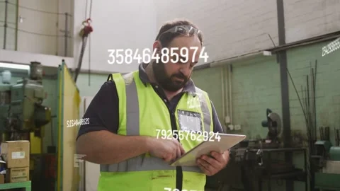 Supervisor tapping tablet, checking production data on plant as numeric overlays Stock Footage 334883913