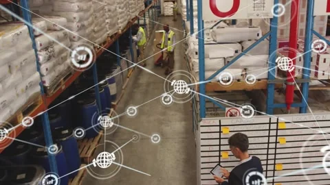 Supervisor tapping tablet, starting warehouse data overlay, handlers moving Stock Footage 330653349