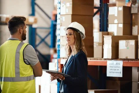 Supervisor, team and supply chain in warehouse with tablet, discussion and .. Stock Photos