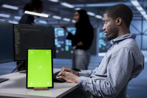 Supervisor using chroma key tablet to reconfigure server room Stock Photos