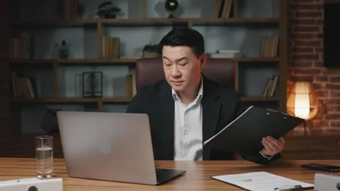 Supervisor working with business papers and laptop in office Stock Footage 245725534