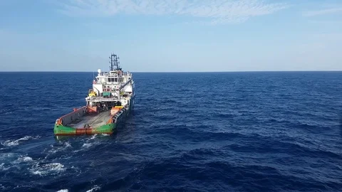 Supply boat pulling anchor for oil drilling rig in the middle of the ocean Stock Footage 82465538