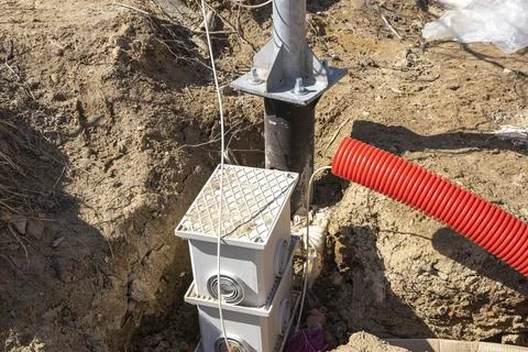Supply of an electric cable to a lamppost. laying of an electric cable Foto stock