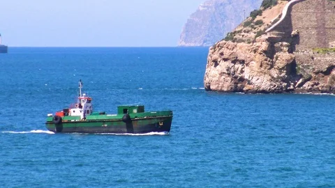 Supply ship sailing close to the lighthouse of the port. Stock Footage 110617962