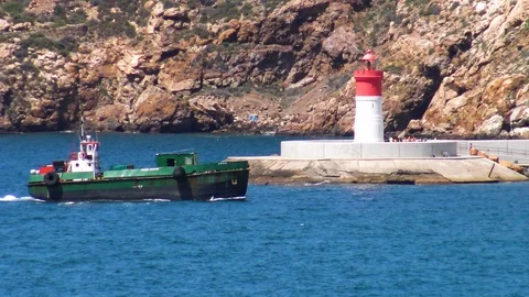 Supply ship sailing close to the lighthouse of the port. Stock Footage 110618092