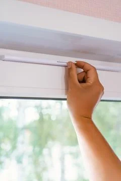 Supply ventilation on a plastic window, a man's hand moves the ventilation le Stock Photos