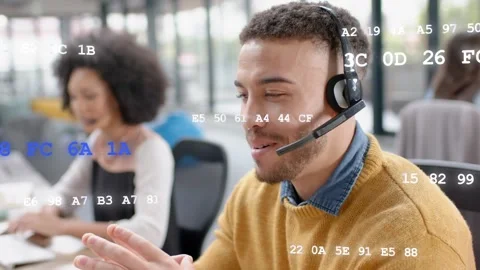 Support agent answering inbound help call, adjusting headset while code graphics Stock Footage 333648642
