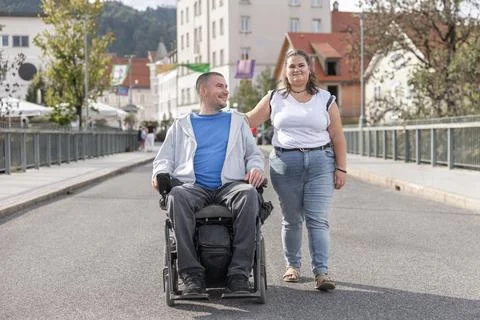 Support and mobility in urban space with wheelchair user and caregiver Stock Photos
