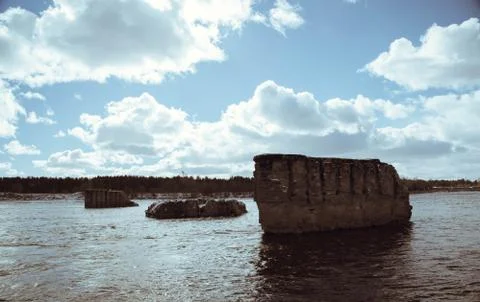 Support the destroyed bridge on river against blue sky Stock Photos