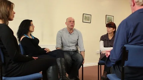 Support group therapy, People sat in circle for a recovery meeting Stock Footage 128376001